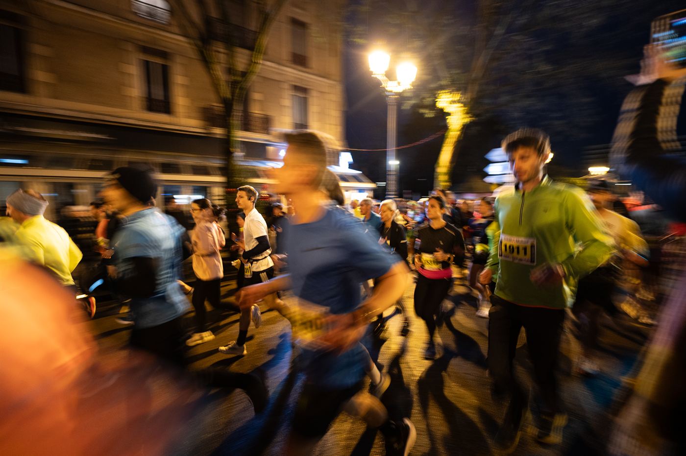 Peloton de coureurs de nuit sous un lampadaire