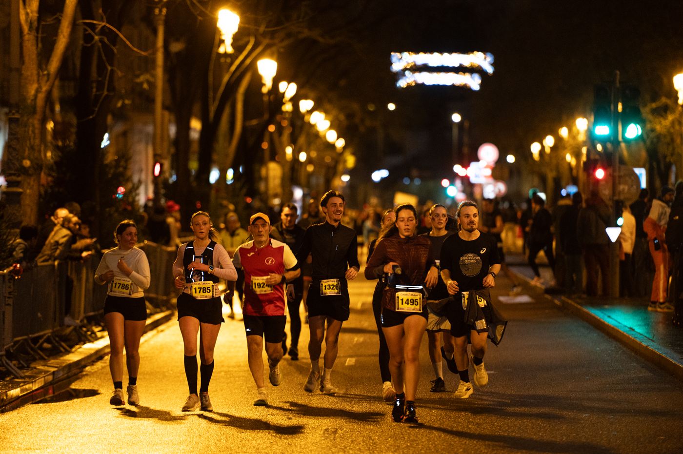 Peloton élancé au départ, boulevard illuminé
