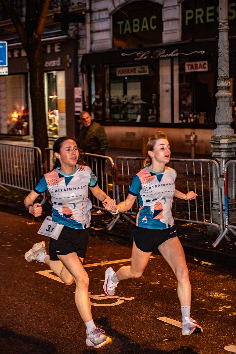 Un duo de coureuses se tient la main pendant la course